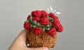 Crochet basket filled with red rolled roses and green leaves